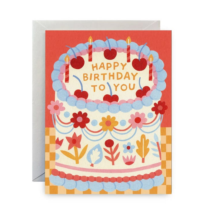Birthday card with a colorful cake illustration and 'Happy Birthday To You' text on a red background.