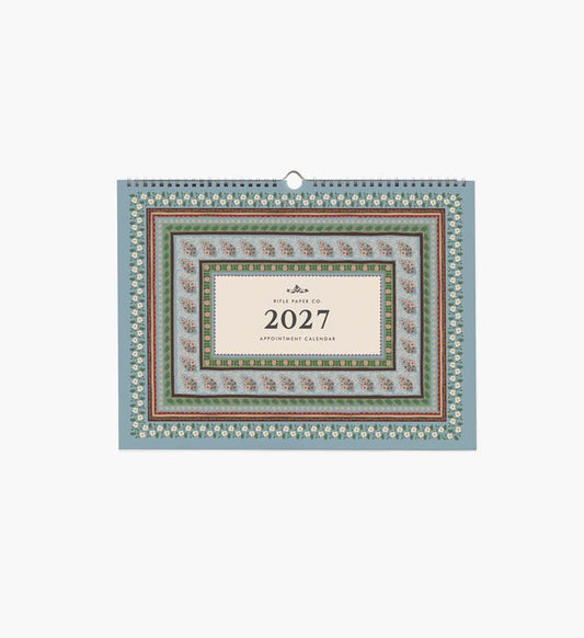 A 2027 wall calendar with a sage green background, white floral pattern, and a dark burgundy central label, shown against a plain white background.