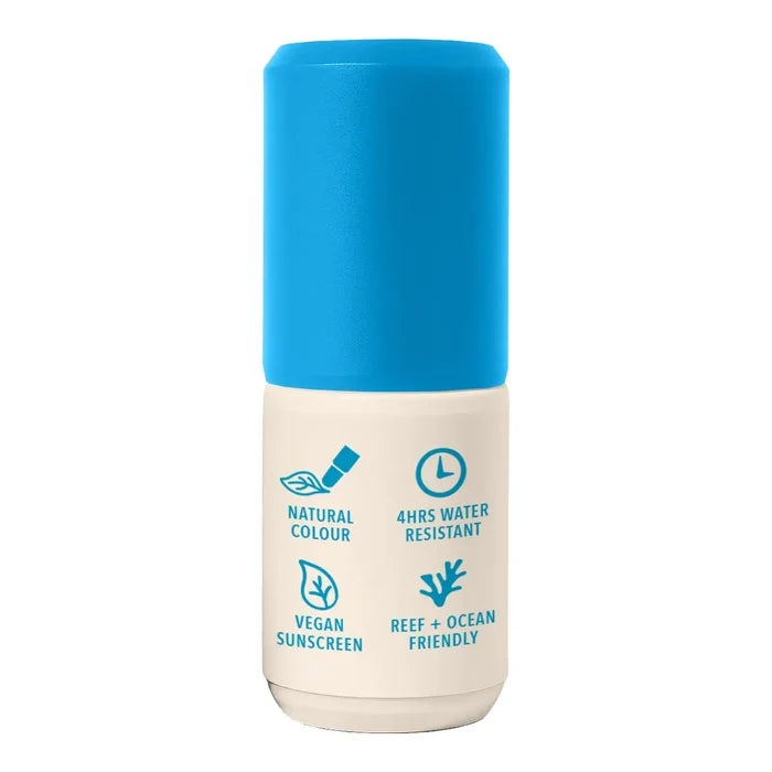 A cylindrical sunscreen bottle with a bright blue cap and a cream-coloured lower body, featuring blue text and icons highlighting product features like natural color, water resistance, vegan sunscreen, and reef and ocean friendliness.