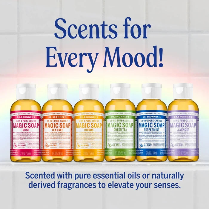 Six Dr. Bronner's Magic Soap bottles in different scents (Rose, Tea Tree, Citrus, Green Tea, Peppermint, Lavender) lined up on a white shelf against a light tiled background.
