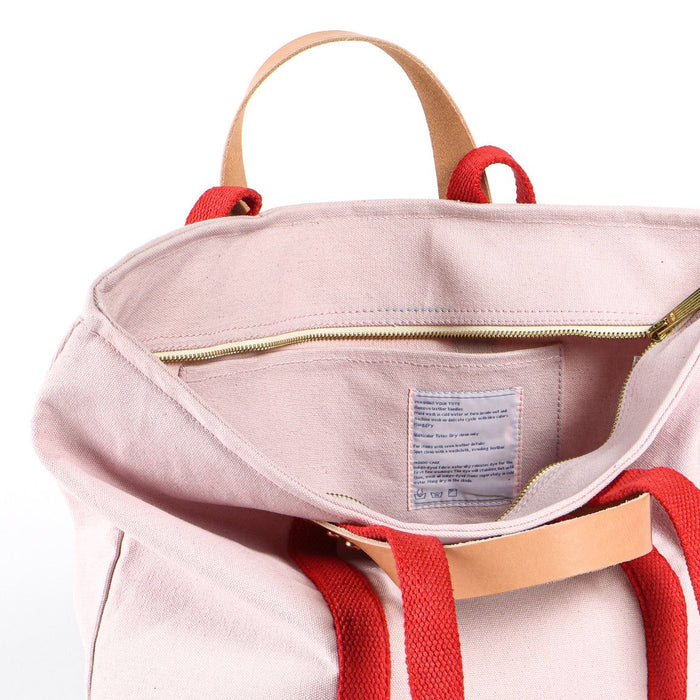Pink backpack with red straps on a white background