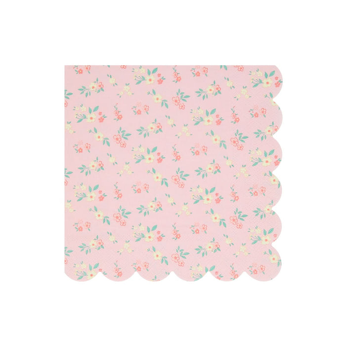 A square pink paper napkin with a scalloped edge, featuring a delicate all-over floral print in soft coral, yellow, and mint green on a light pink background.