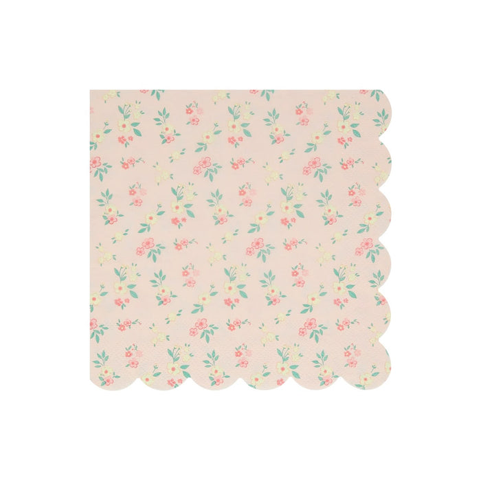 A square paper napkin with a scalloped edge, featuring a delicate pastel floral pattern on a light pink background.